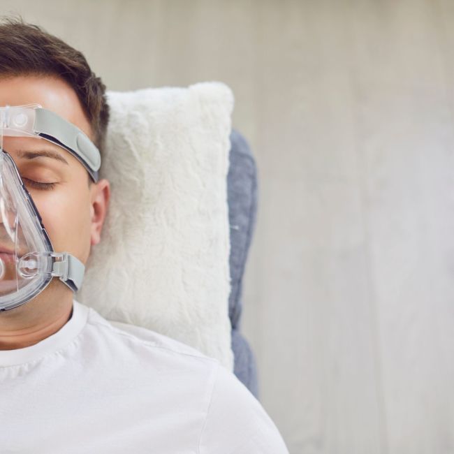Schlafapnoe - Junger Mann mit Maske